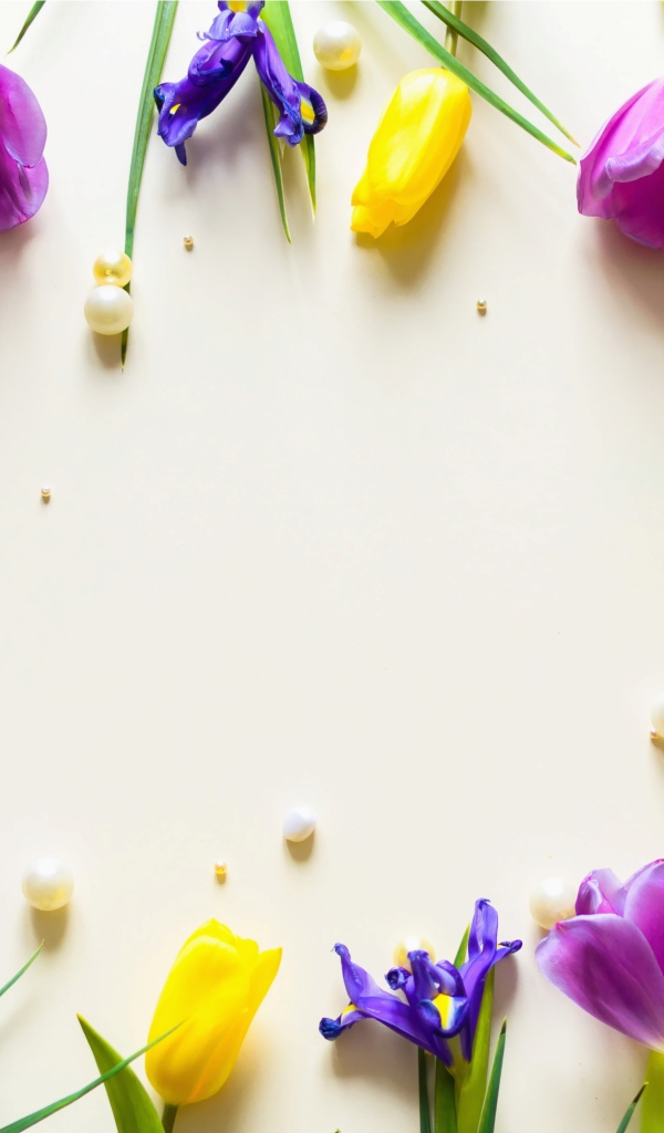 Тюльпаны  и ирисы с жемчужинами на столе 