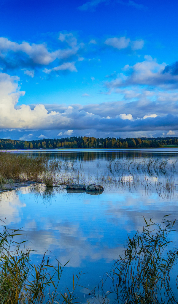 Голубое небо с облаками отражается в озере