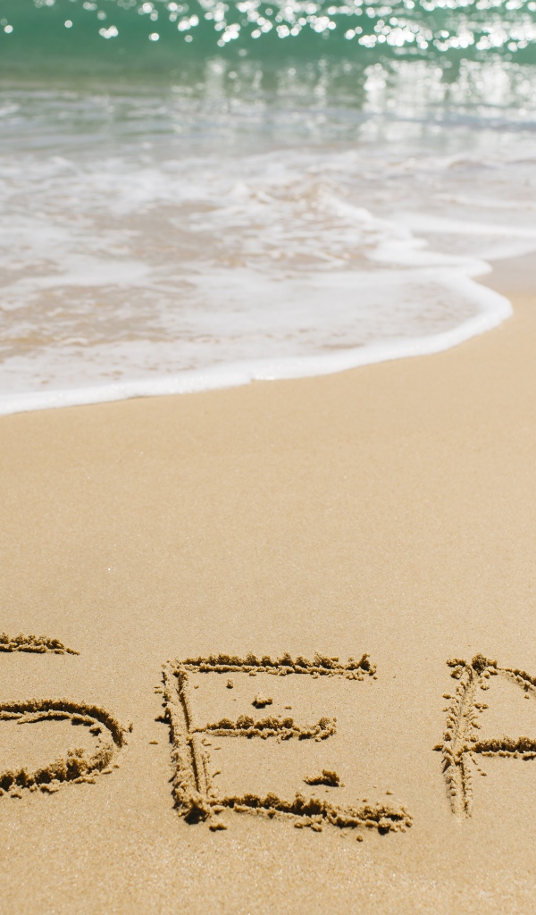 Надпись на песке у моря летом