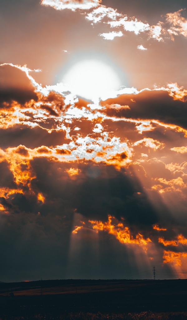 Яркое солнце в облаках на закате 