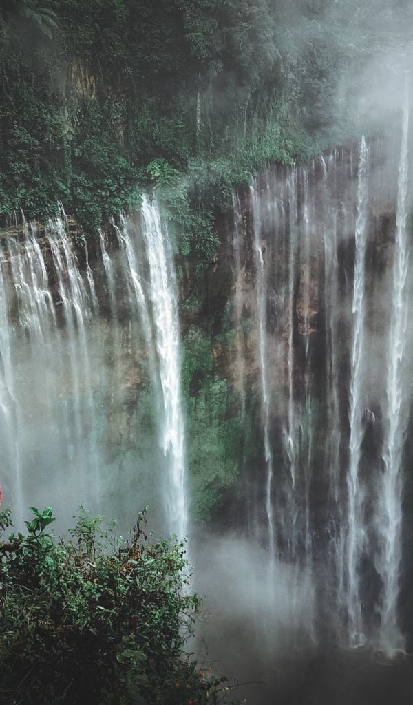 Человек смотрит на водопад сверху. 