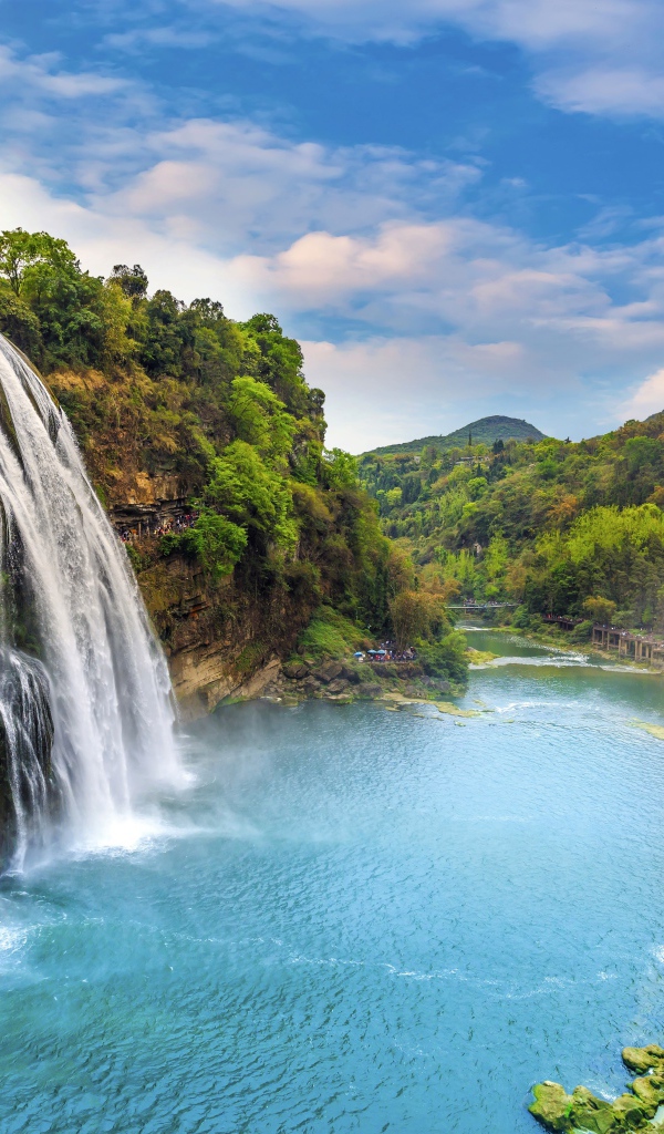 Красивый водопад стекает с утеса под голубым небом