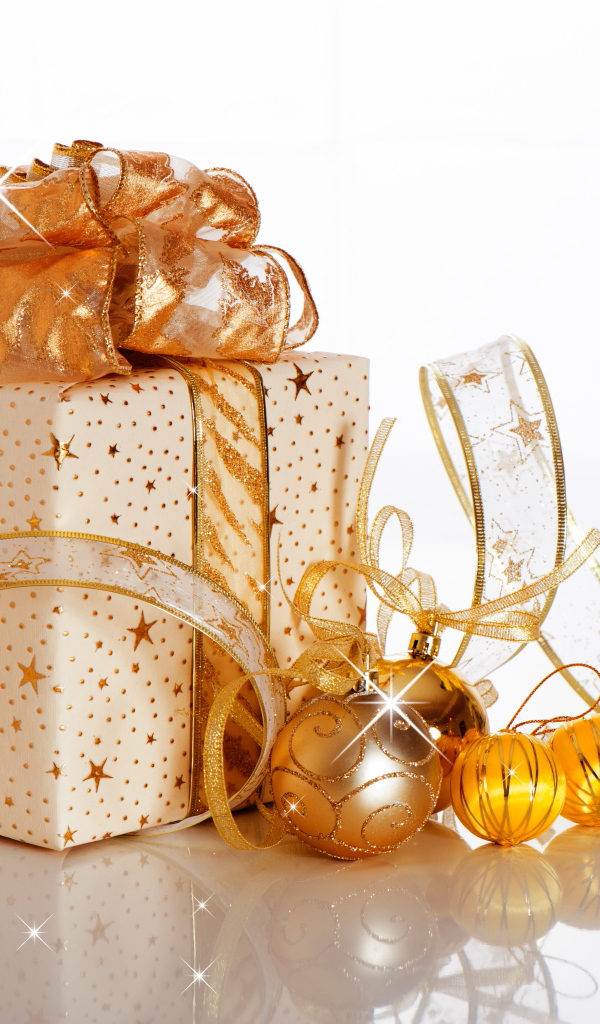 Красивый подарок с лентой и елочными шарами на белом фоне на Новый год 2019