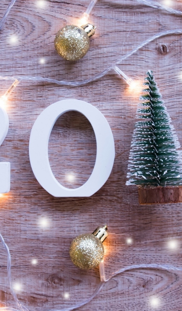Цифры 2019 на деревянном фоне с елочными игрушками и гирляндой