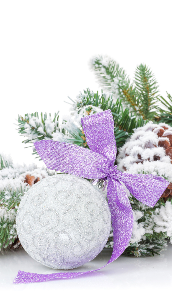 Серый елочный шар с бантом на зеленой ветке на Новый год 2019