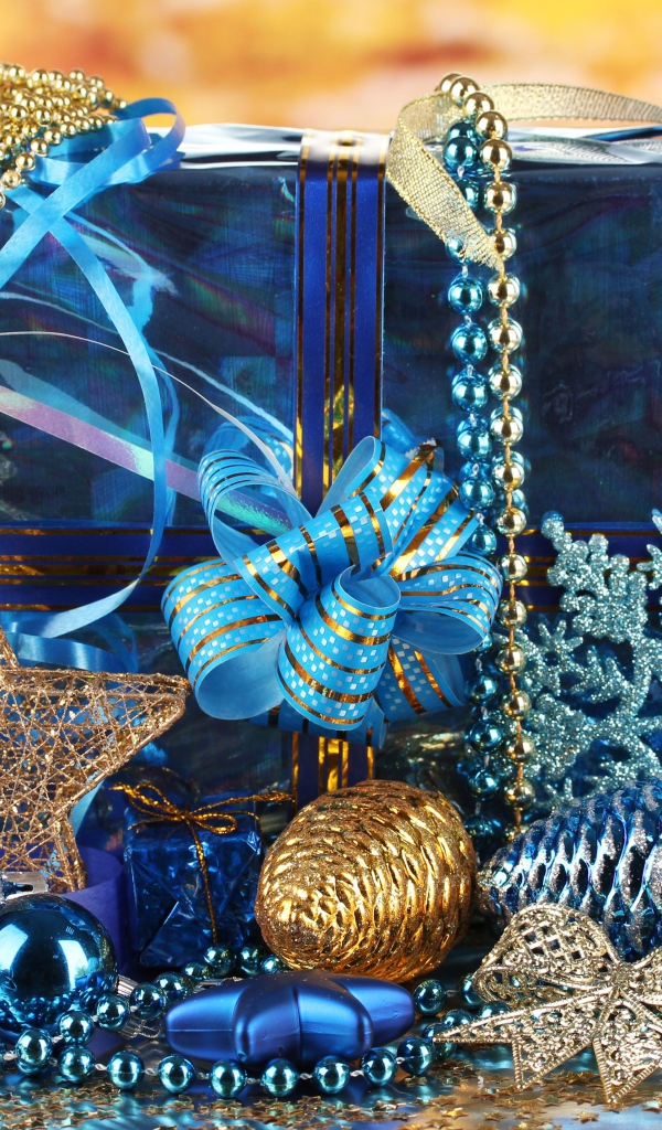 Большой подарок в голубой упаковке с украшениями на Новый год 
