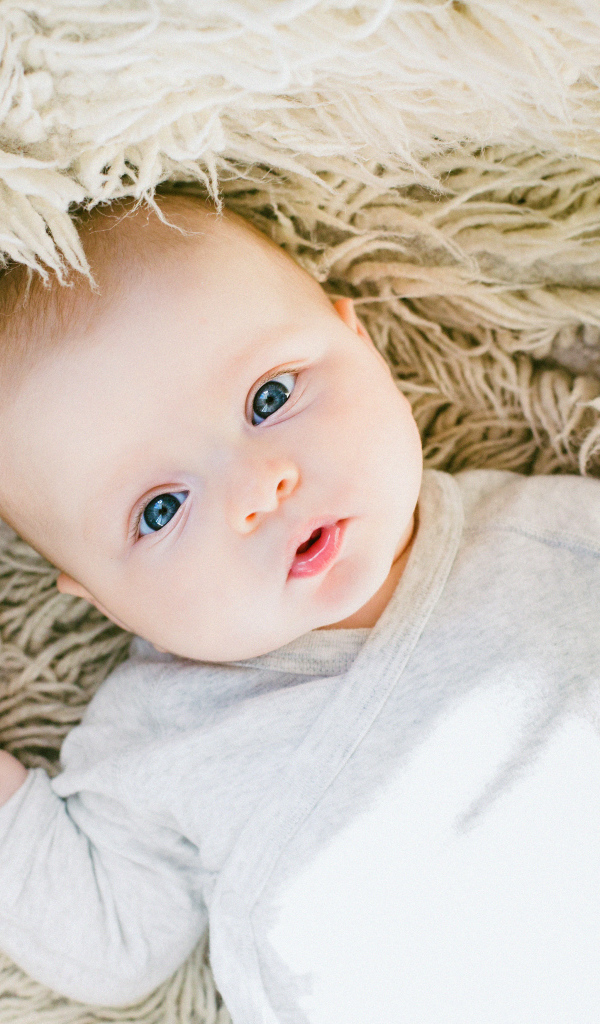 Милый младенец лежит на меховой накидке