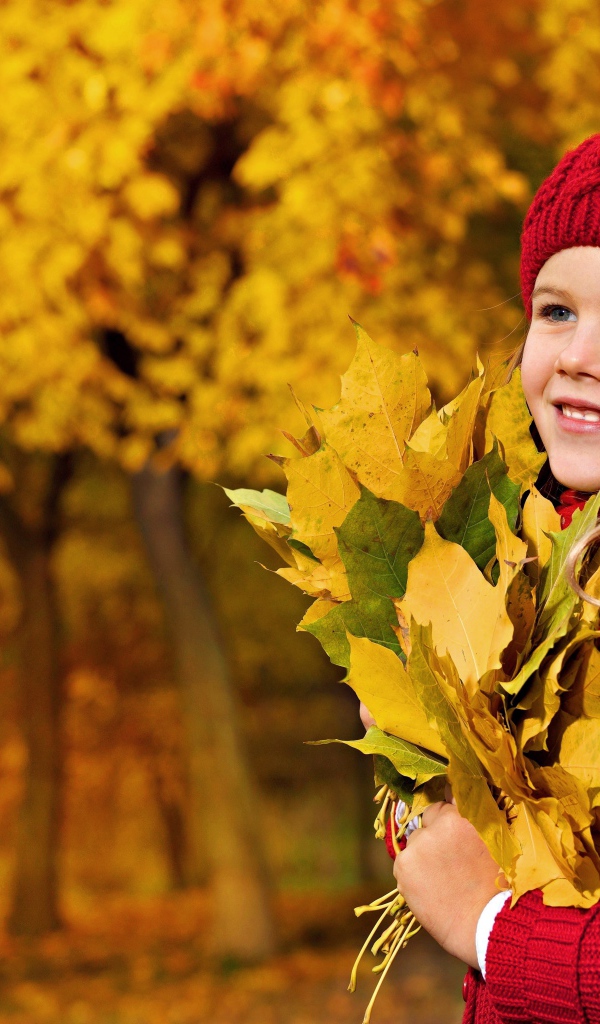 Девочка в красном берете с желтыми листьями в руках