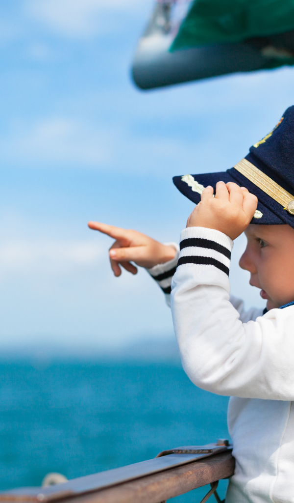 Маленький мальчик в форме капитана на корабле