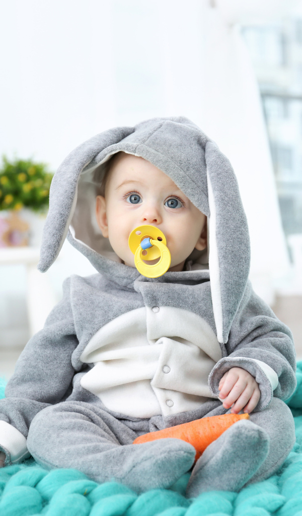 Маленький милый мальчик в костюме с пустышкой во рту