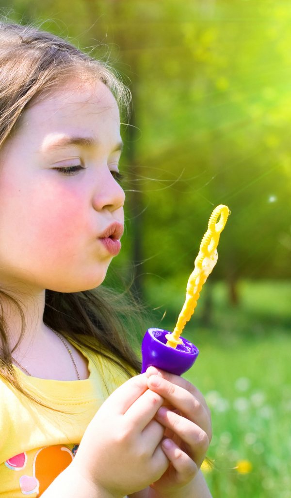 Маленькая девочка с мыльными пузырями в руках