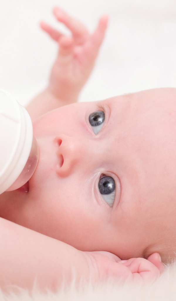 Новорожденного ребенка кормят с бутылки