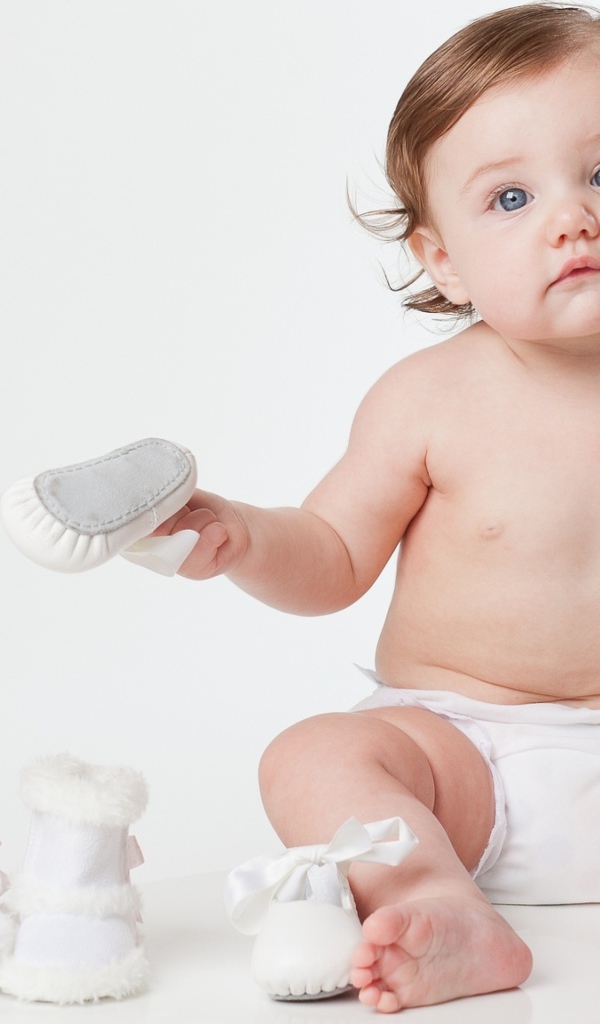 Маленький грудной ребенок с детской обувью