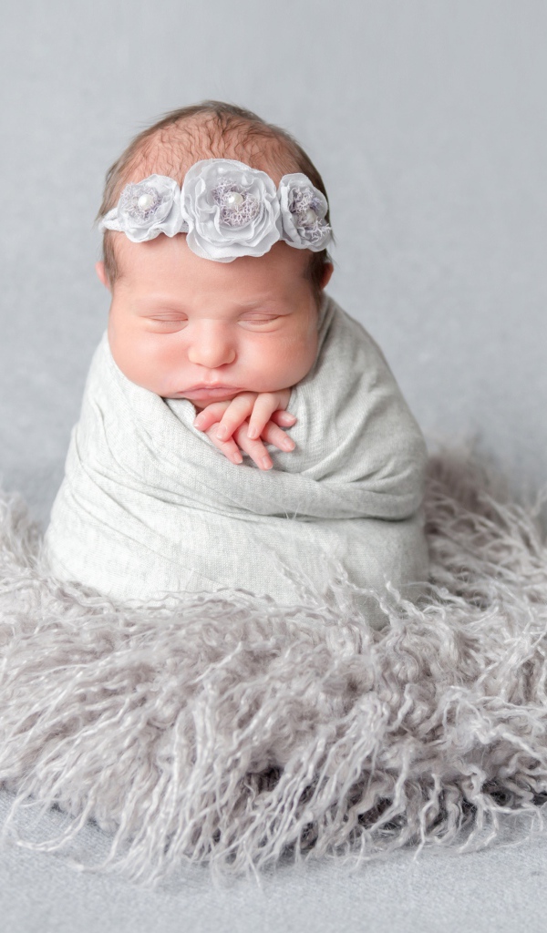 Маленький спящий младенец на сером фоне