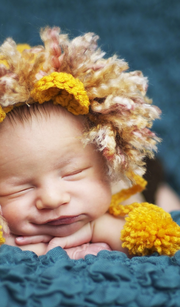 Милый спящий младенец в забавной шапке львенка