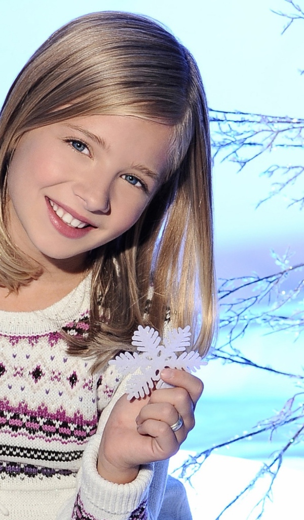 Красивая улыбающаяся девочка блондинка со снежинкой в руке