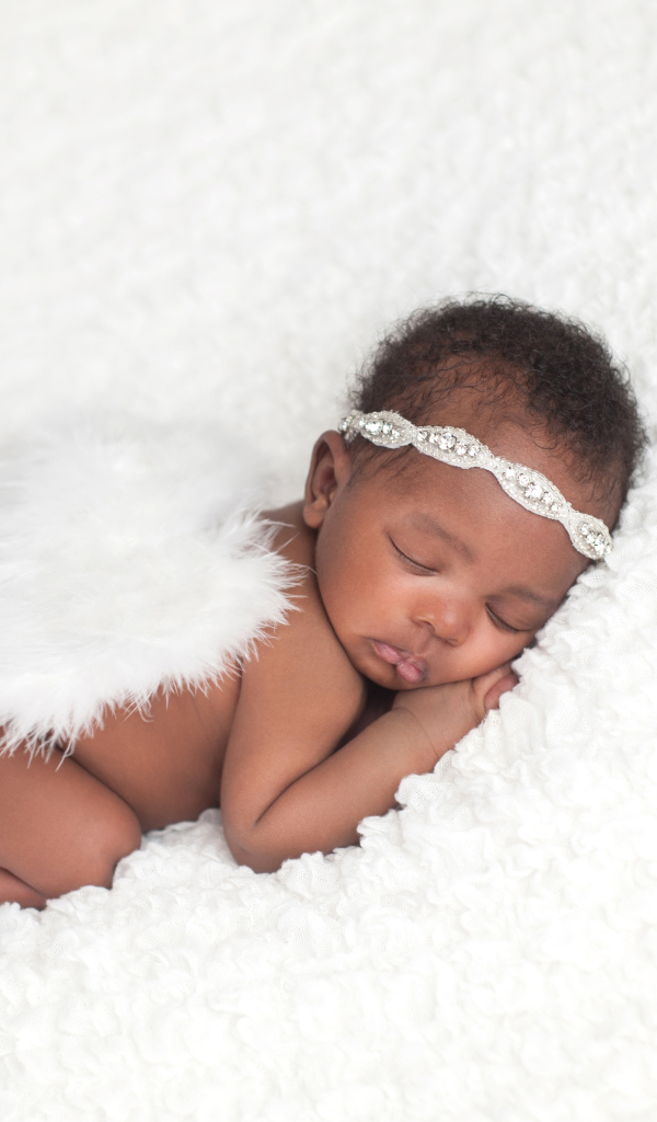 Темнокожий младенец спит с крыльями ангела