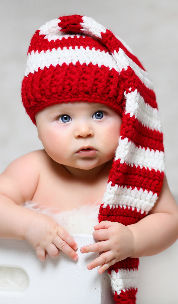Голубоглазый младенец в длинной вязаной шапке
