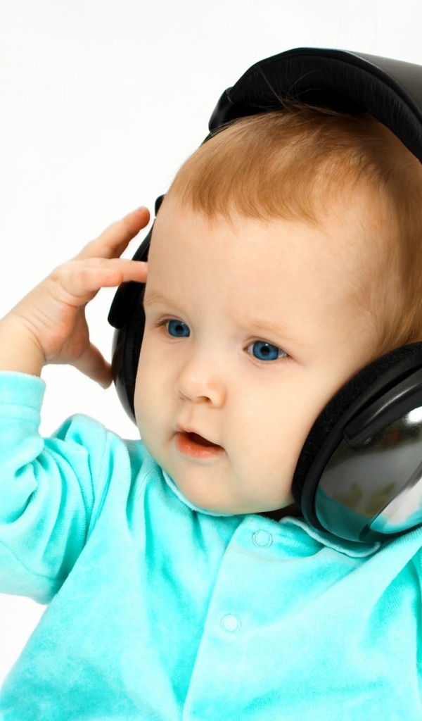 Голубоглазый мальчик в больших наушниках на белом фоне