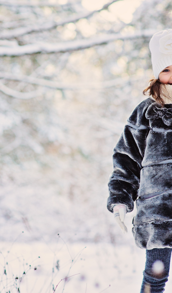 Милая маленькая девочка в шубе зимой