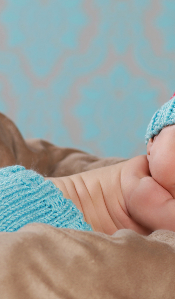 Забавный спящий младенец в голубом вязаном костюме 