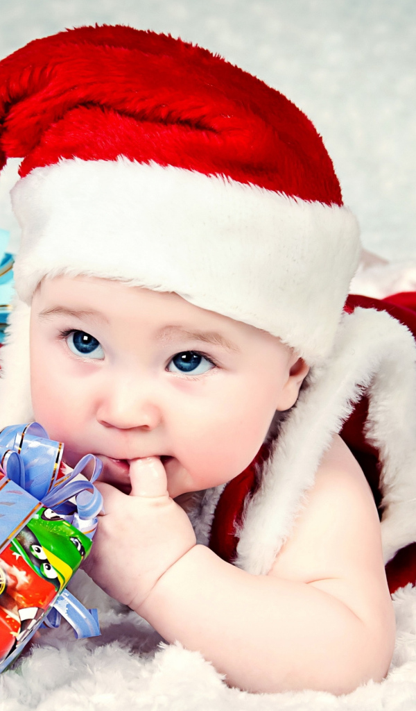 Маленький ребенок в новогоднем костюме с подарками