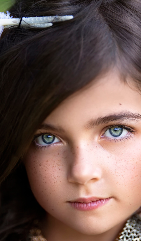 Маленькая красивая девочка с белым пером в волосах