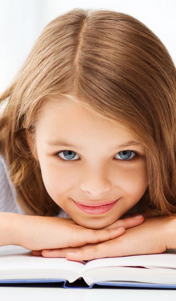 Маленькая голубоглазая девочка школьница с книгой 