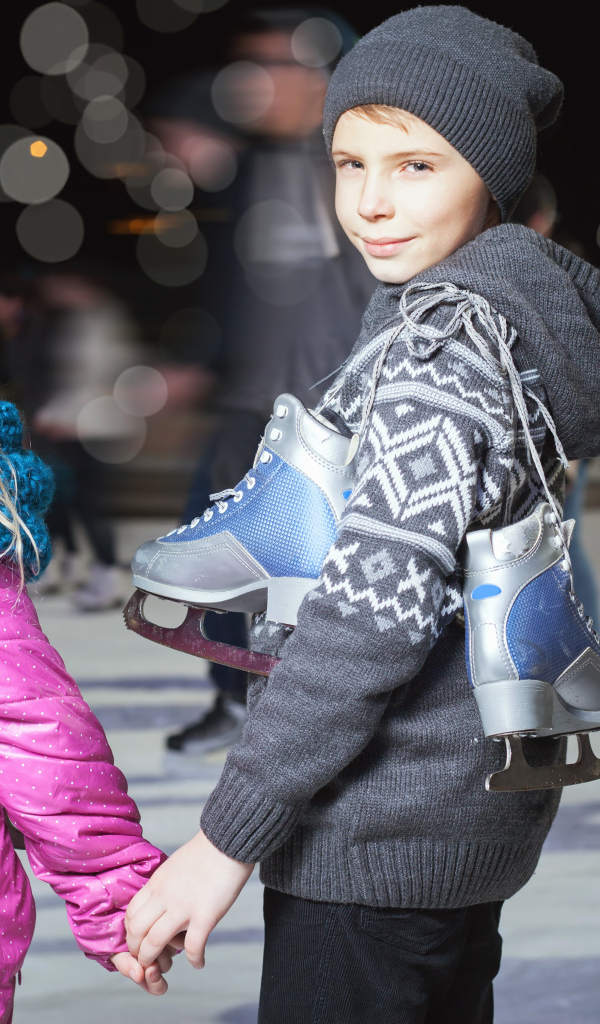 Маленькие мальчик и девочка на катке