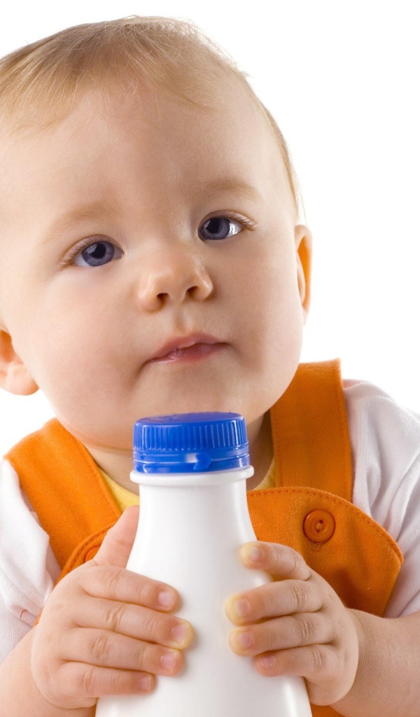 Маленький мальчик с бутылкой молока на белом фоне