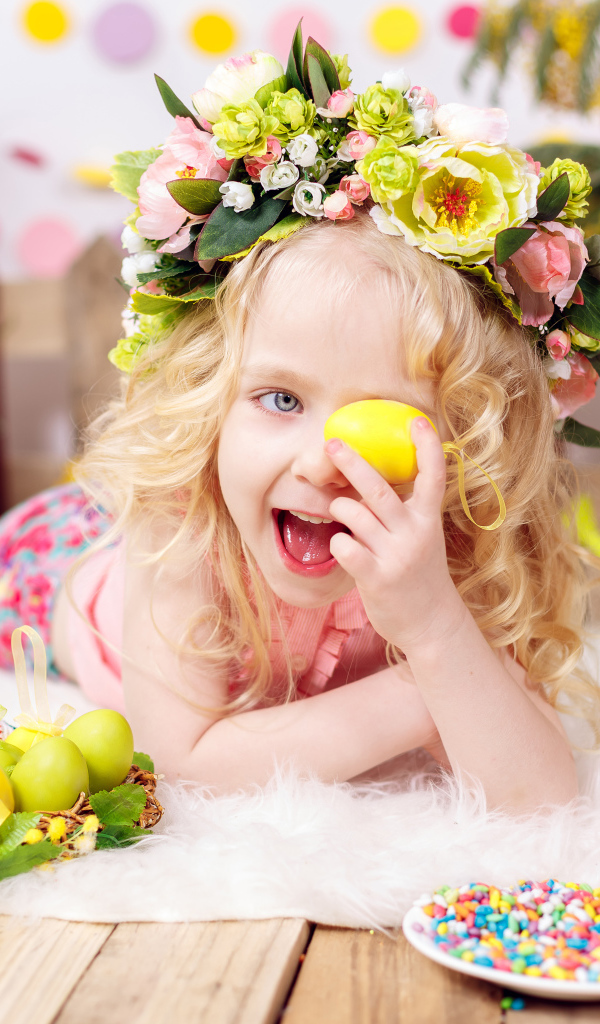 Маленькая веселая девочка с пасхальными яйцами