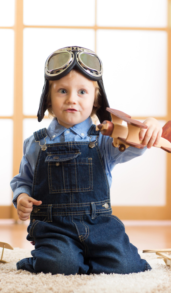 Маленький будущий летчик играет с самолетом