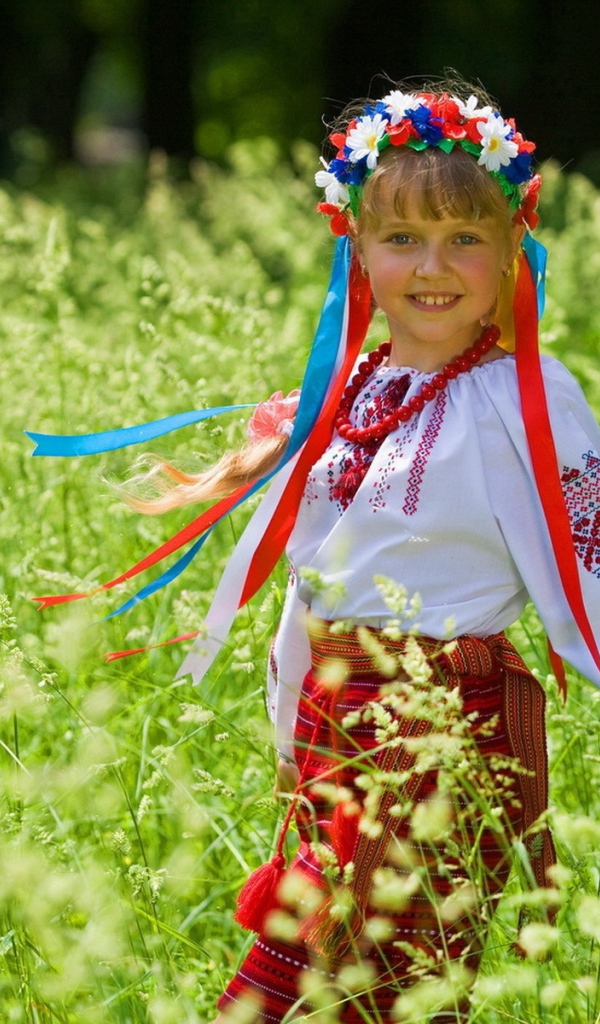 Маленькая девочка в костюме с венком на голове