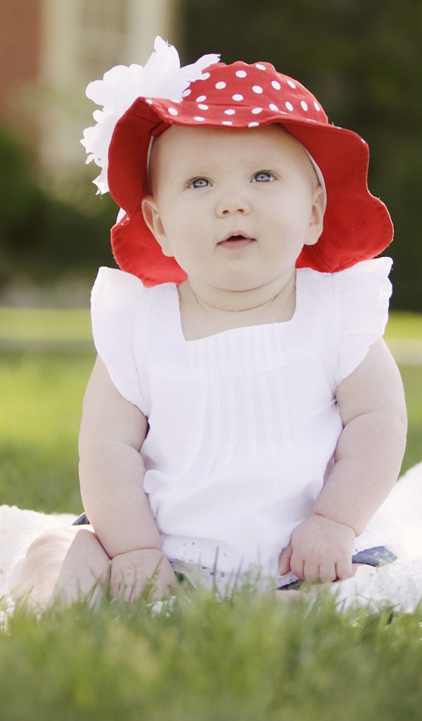 Маленькая девочка в белом платье и красной шляпе