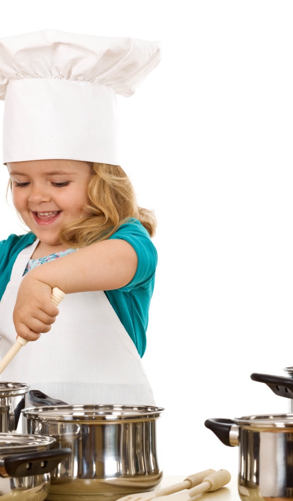 Маленькая девочка в костюме повара на кухне