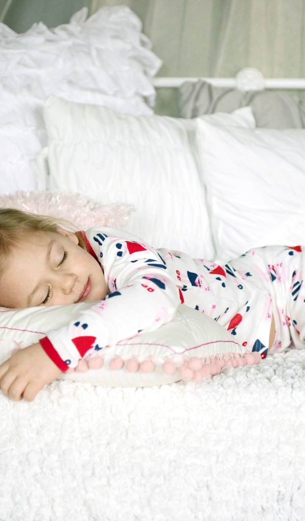 Маленькая девочка спит на подушке