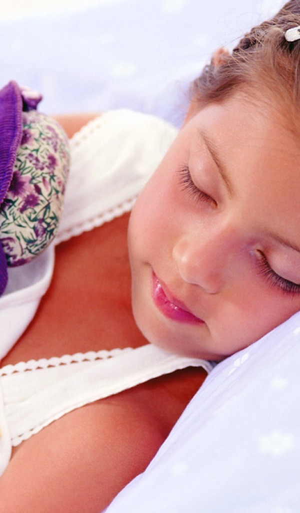 Маленькая девочка спит с игрушкой