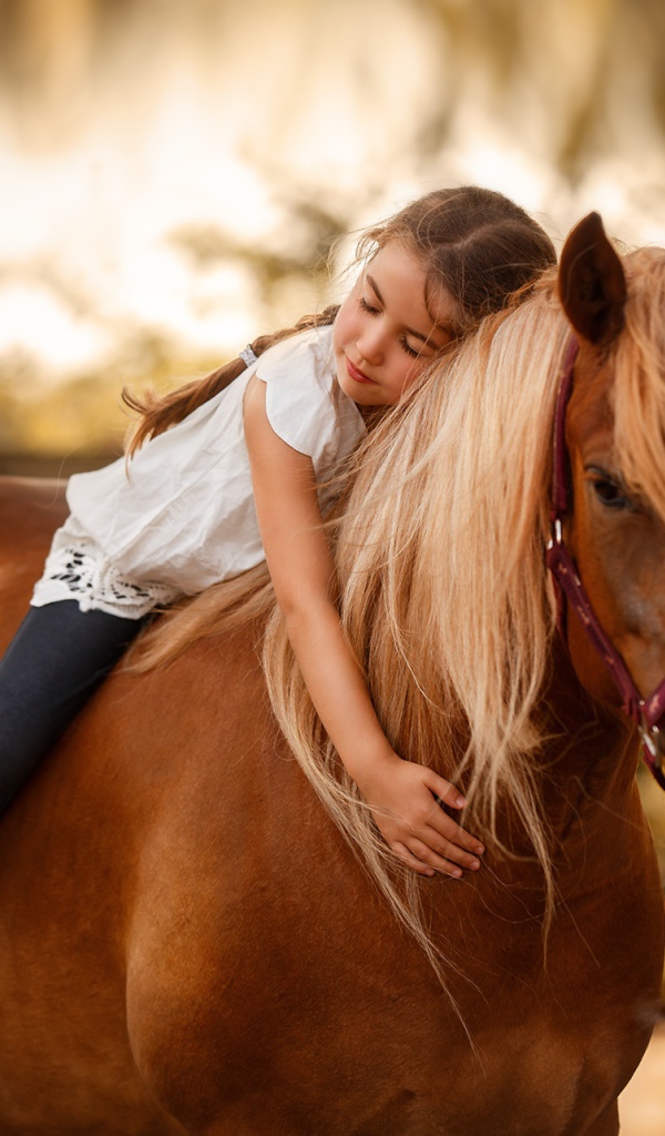 Маленькая девочка сидит на коне