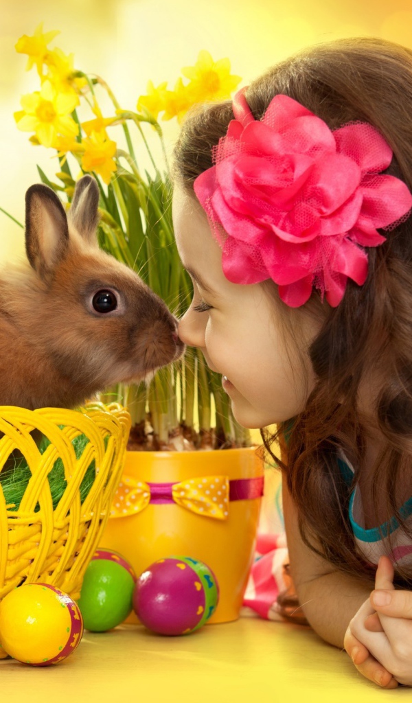 Маленькая девочка с кроликом в корзине на праздник Пасха
