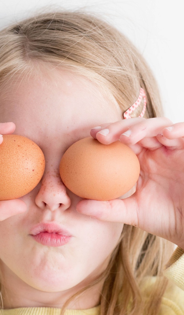 Маленькая девочка с яйцами в руках