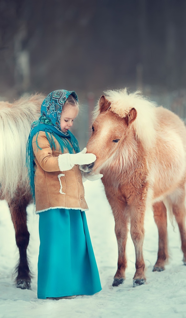 Little girl with pony in winter