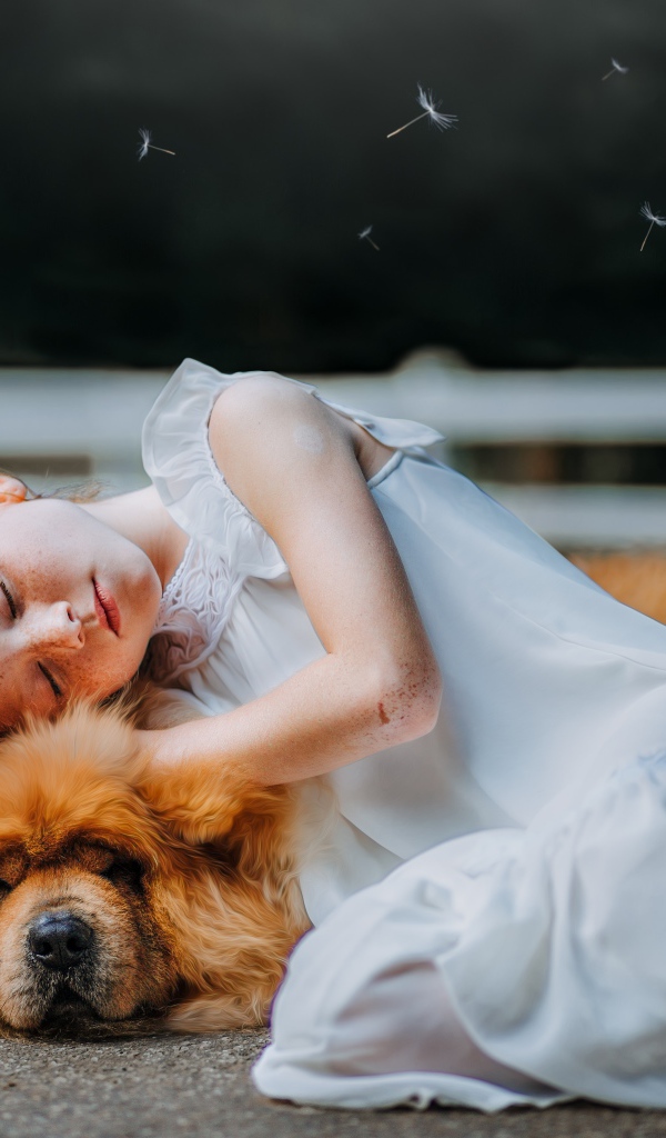 Маленькая рыжеволосая девушка в белом платье с собакой