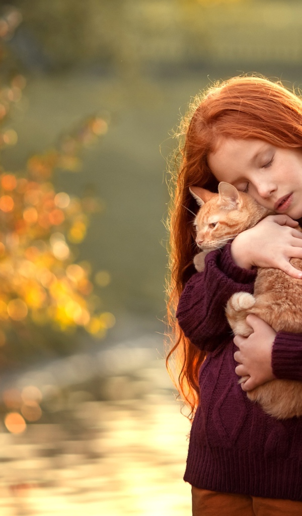 Маленькая рыжеволосая девочка с котенком на руках