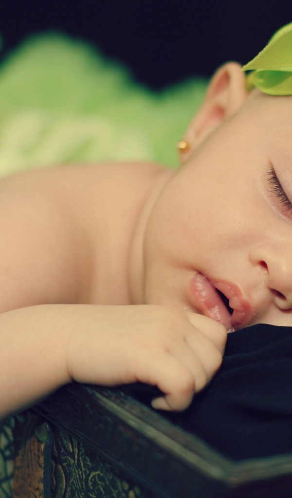 Маленькая спящая девочка с ленточкой на голове