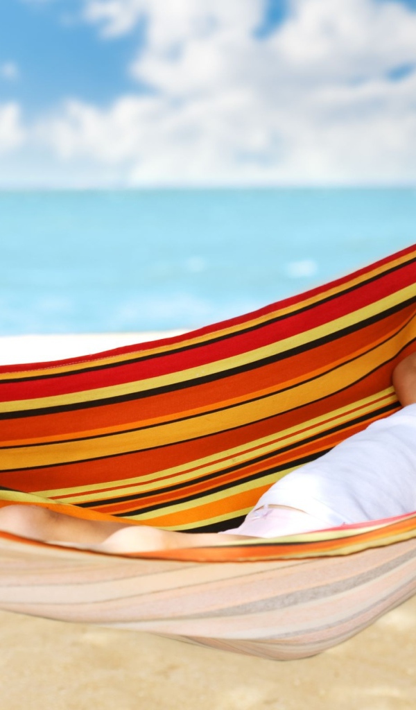 Маленькая улыбающаяся девочка в гамаке на пляже