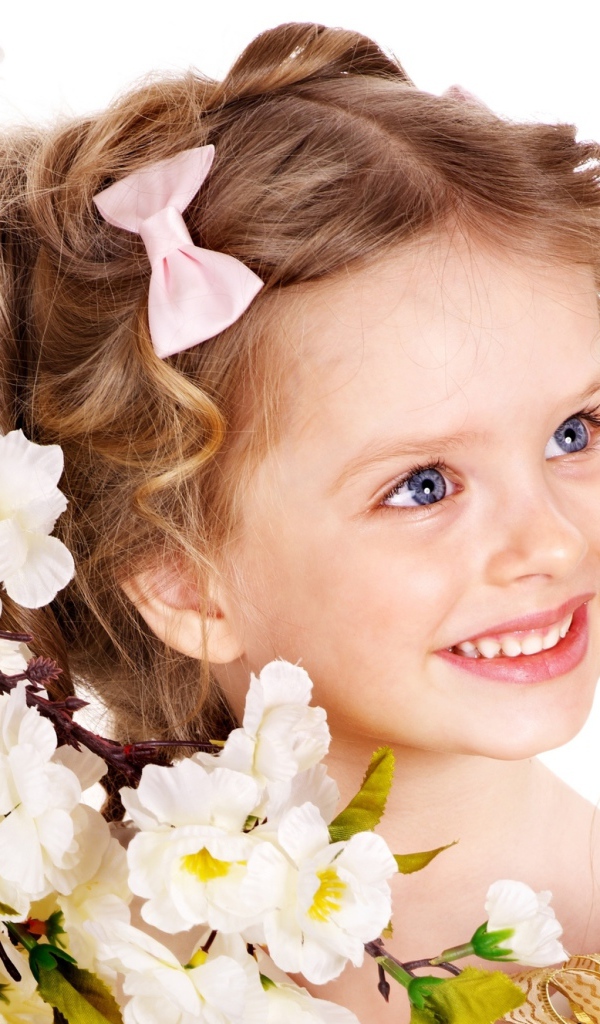 Маленькая улыбающаяся девочка с цветущей веткой