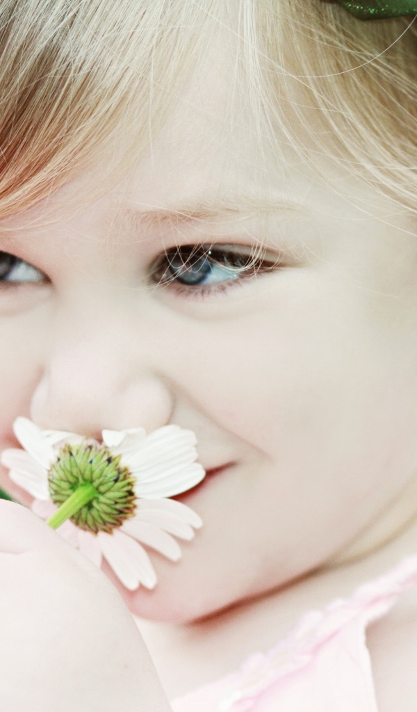 Милая девочка с красивыми глазами с ромашкой