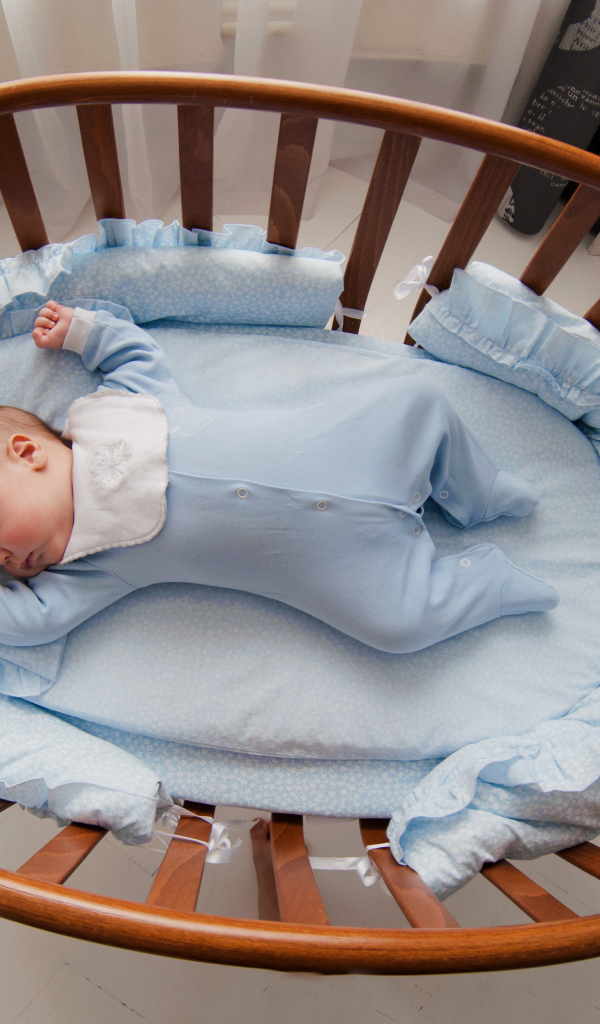 Спящий грудной ребенок в кроватке