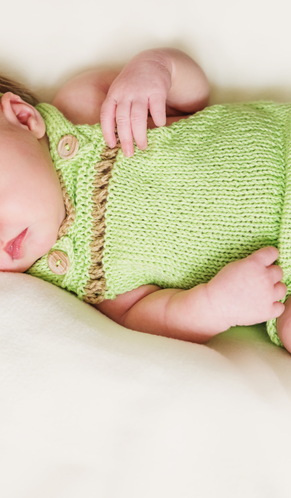 Спящий младенец в вязаной одежде