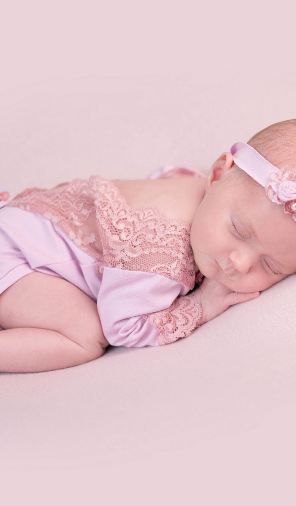 Спящий грудной ребенок на розовом фоне